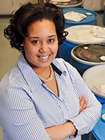 Graduate student stands in front of barrels